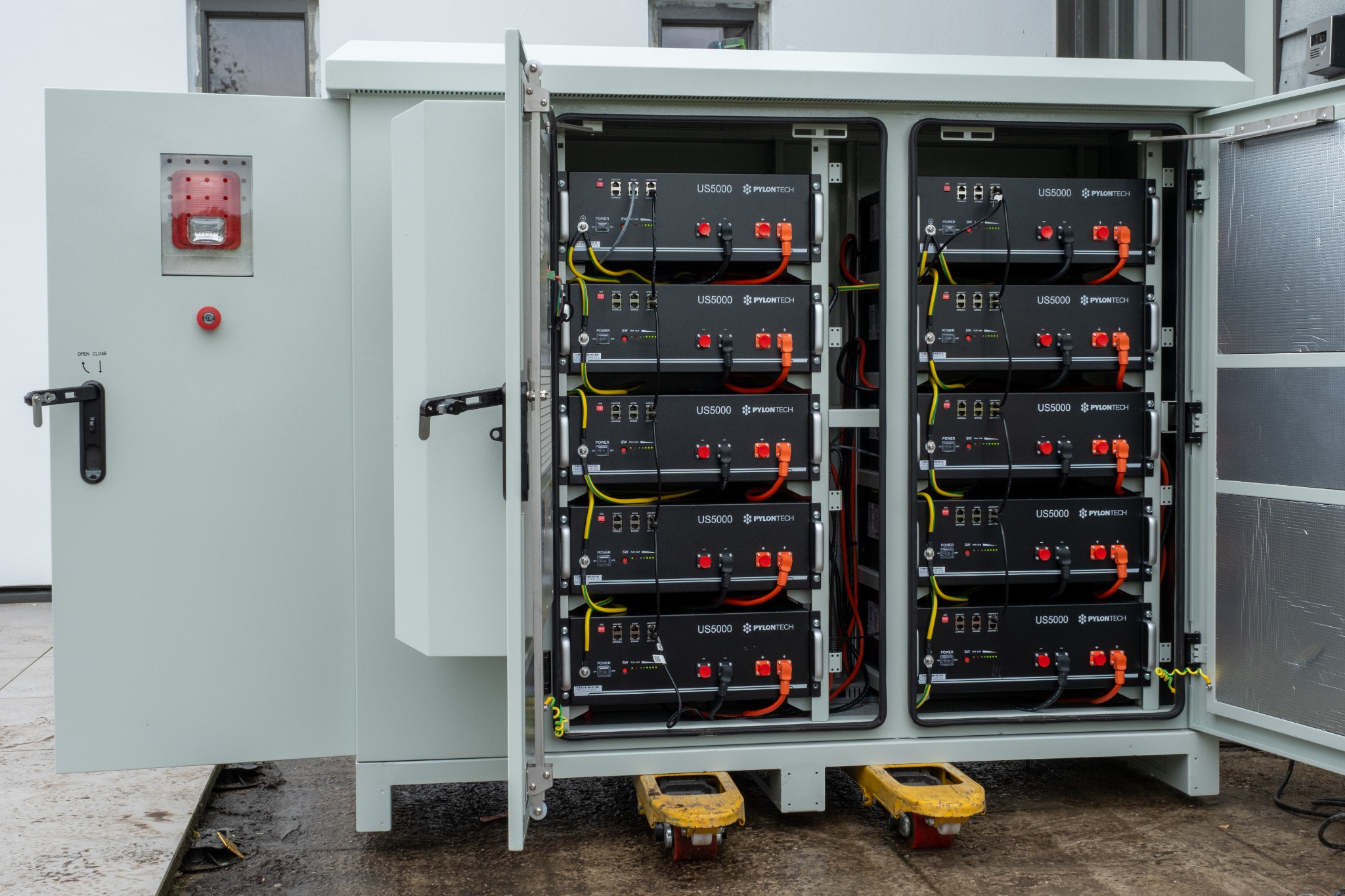 Geopende batterijkast met twee rijen batterijmodules bij een energieopslaginstallatie