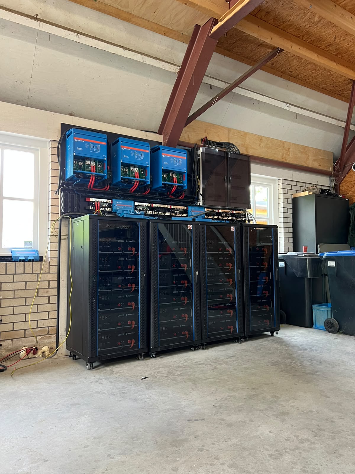 Batterijrekken en Victron-omvormers in een hoge bedrijfsruimte