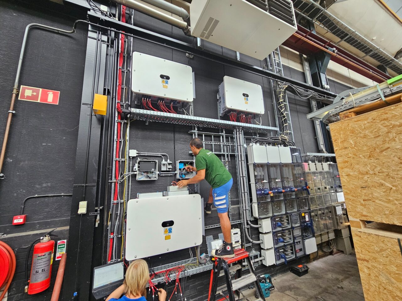 Monteur werkt aan omvormers en verdeelkasten van een energie-installatie