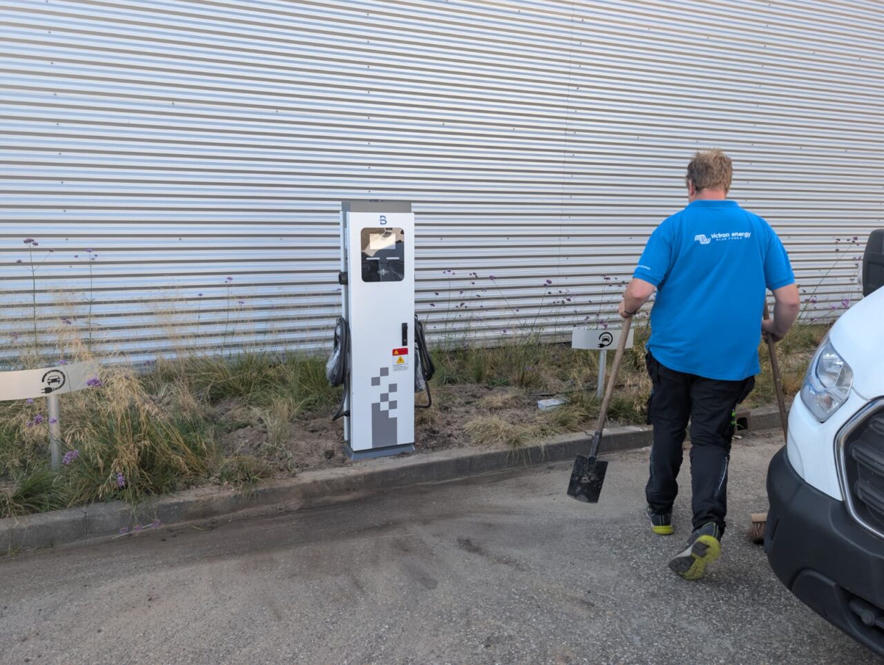 Installateur bij een laadpunt aan de buitenzijde van een bedrijfspand