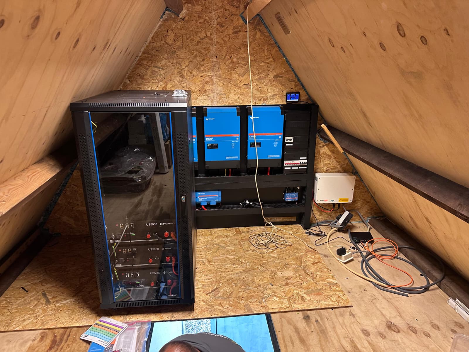 Batterijrek en Victron-omvormers in een technische ruimte onder een schuin dak